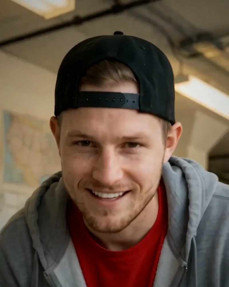 Headshot of Brett Deadhead in a backwards cap and gray hoodie